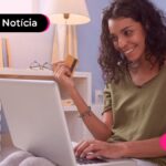 Moça comprando no cartão em site online pelo notebook.