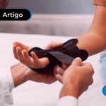 Profissional da saúde colocando uma tala na mão de uma pessoa.