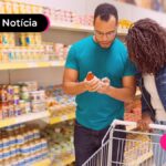 Casal em mercado olhando preços.