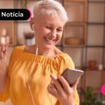 Idosa usando uma camiseta amarela e um fone de ouvido.