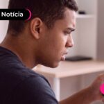 Jovem olhando para o celular expressando dúvidas.