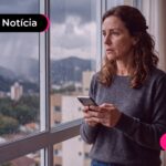 Mulher olhando para janela expressando uma feição de tristeza.