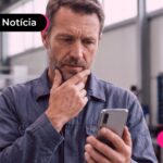 Homem olhando para o celular expressando uma feição de dúvidas.
