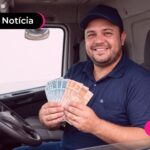 Homem sorrindo dentro de um veículo e segurando dinheiro.
